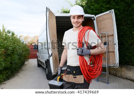 handsome young construction worker with his commercial van on background