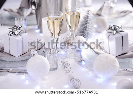 bright white and silver new year eve or christmas table in a luxury restaurant with champagne