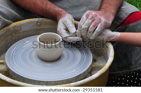 fabrication of the crockery on potter\'s wheel by pupil with teacher
