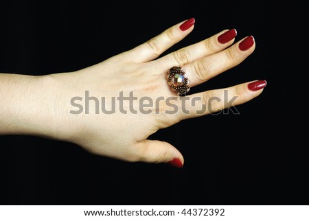 ring set with a stone from glass beads  brown on finger of the hand