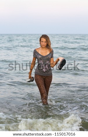 Girl in wet clothes comes out of the sea