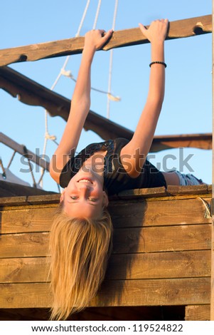 Happy girl lying on the deck of an old wooden ship
