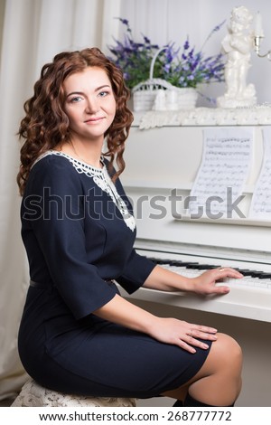 Portrait of curly redhead woman sitting at the piano