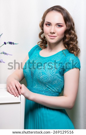 Portrait of pretty woman posing in turquoise dress