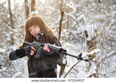 Armed young brunette girl aiming a gun
