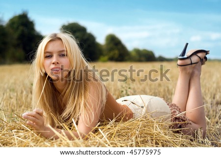 Young playful blonde lying in the field