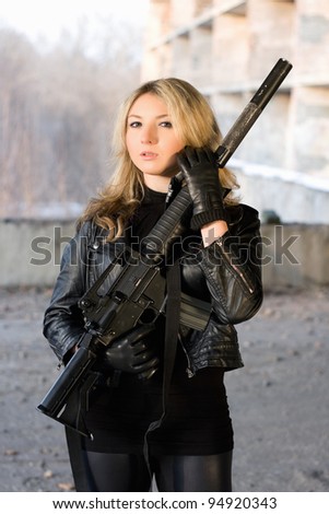 Hot woman in leather jacket holding a rifle
