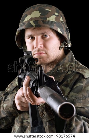 Soldier holding a gun in studio. Isolated