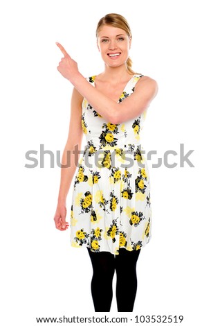 Pretty woman pointing upwards against white background