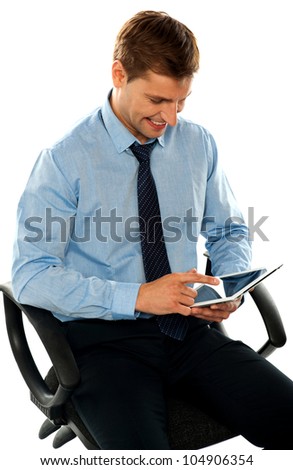 Businessman watching videos on his new  tablet pc. Sitting on chair
