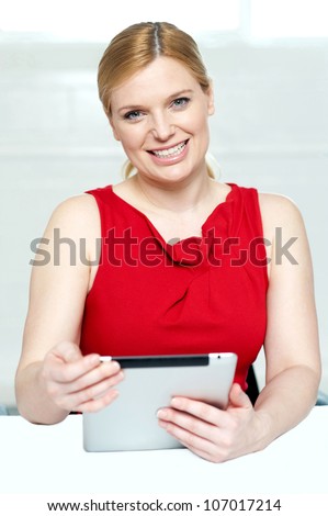 Beautiful young woman holding portable tablet pc isolated against gray background