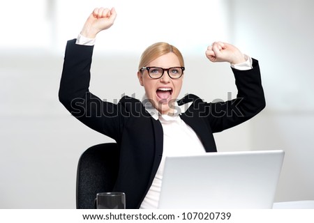 Excited young businesswoman completing looking upwards. Success portrait