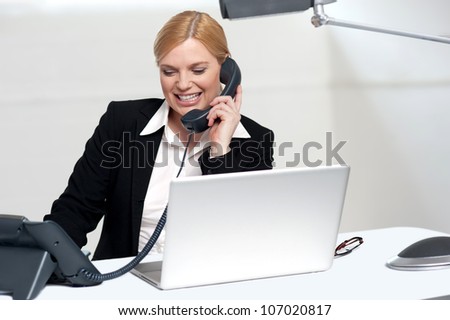 Female secretary communicating with her boss on phone in the office