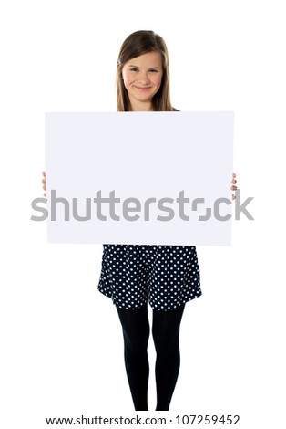 Smiling cute isolated girl displaying blank white poster