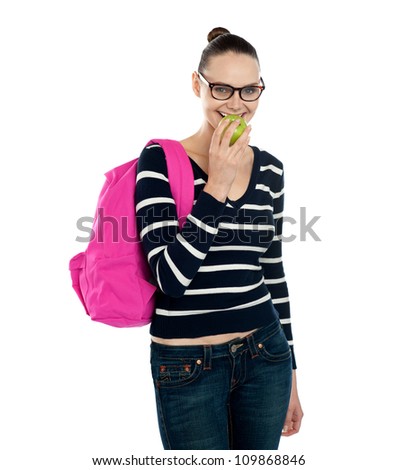 College student carrying school bag and eating fresh green healthy apple