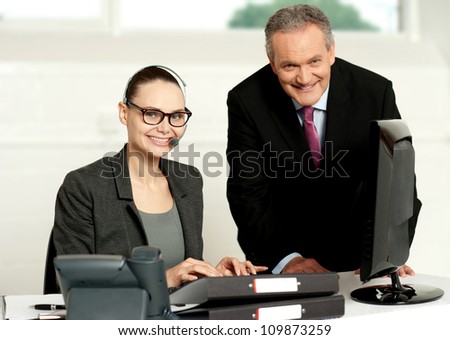 Cheerful corporate people at work in office. Woman typing on keyboard
