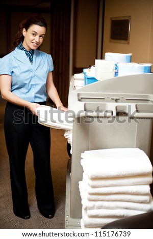 Housekeeping in charge pulling out the bath towel from the cart to deliver it to rooms