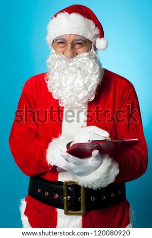 Santa Claus making his list of the good children. Is your name in it?