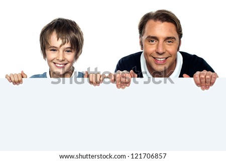 Father and son posing behind big blank banner ad. Isolated over white.