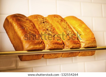 Variety display of loafs of grain and white breads.