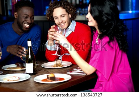 Group of friends having their dinner with drinks at a restaurant.