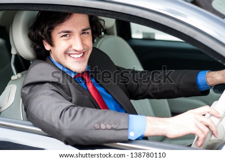 Smart handsome corporate man driving his car.