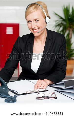 Female executive talking to client through headphones.