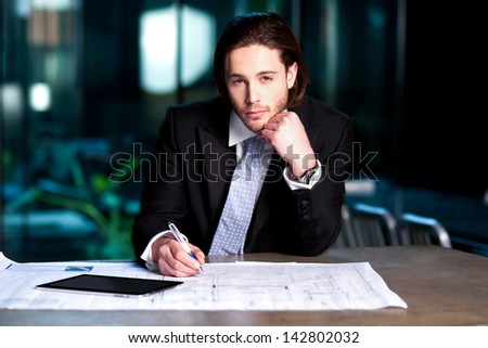 Handsome young businessman busy with his project plan