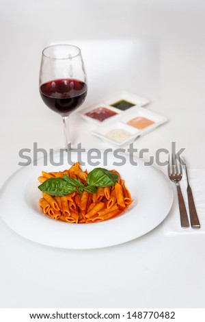 Yummy pasta served with sauces and red wine