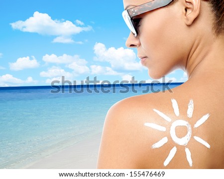 Rear view image of a woman with sunscreen lotion