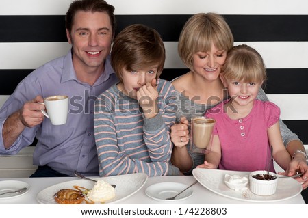 Cheerful caucasian family of four having fun in restaurant