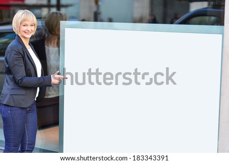 Business woman pointing at blank whiteboard