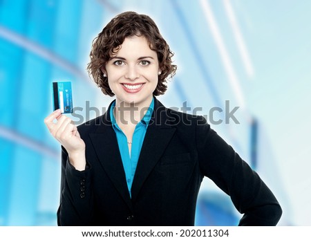 Smiling corporate lady displaying credit card.