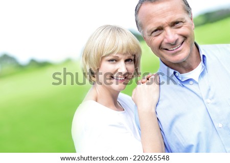 Happy middle aged couple posing together at outdoors