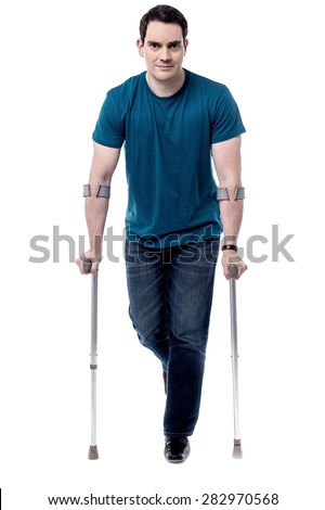 Full length of middle aged man walking with crutches