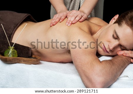Masseur doing massage on back of man body