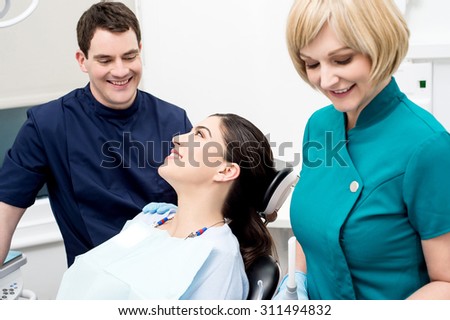 Dentist and his patient discussing in examination room