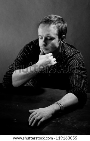 sad business man sitting down. black and white portrait