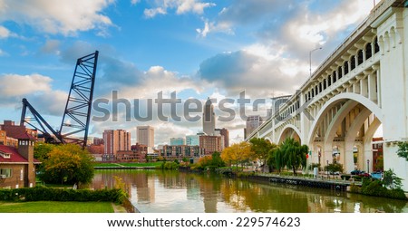 The Cuyahoga River bends past downtown Cleveland by the Veterans Memorial Bridge with old lift bridge at left
