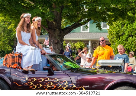 TWINSBURG, OH, USA - AUGUST 8, 2015: Twin sisters dressed as fair maidens ride in the Double Take Parade, part of the 40th annual Twins Day festival, the largest gathering of twins in the world.