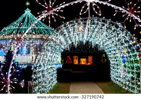 A tunnel of lights and icicle decorations with a festively lit gazebo at Christmas