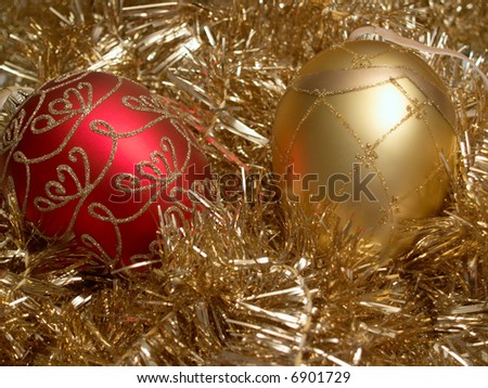 Red and gold Christmas ornaments on a bed of gold tinsel