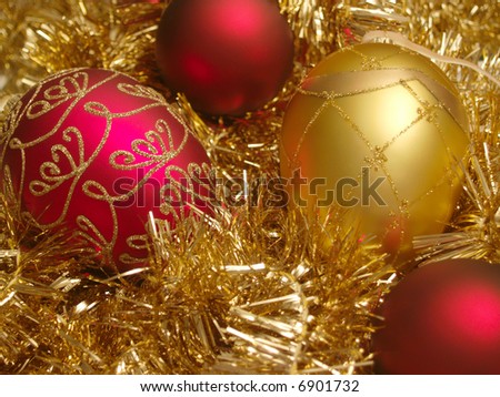 Red and gold Christmas ornaments nested in gold tinsel