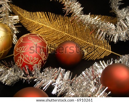 Arrangement of Christmas ornaments and tinsel on black