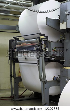 Giant paper rolls on a web press in a publishing company