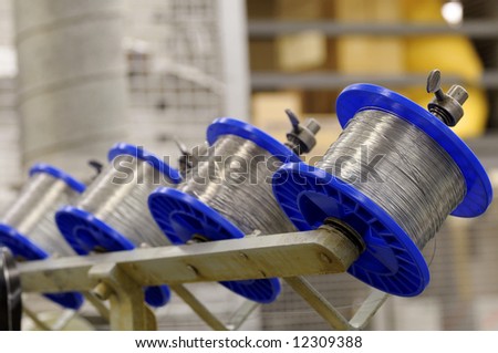Spools of wire on a stitching machine in a printing plant