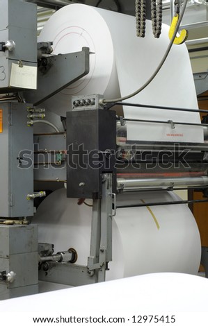 Large rolls of new paper on a four-web printing press