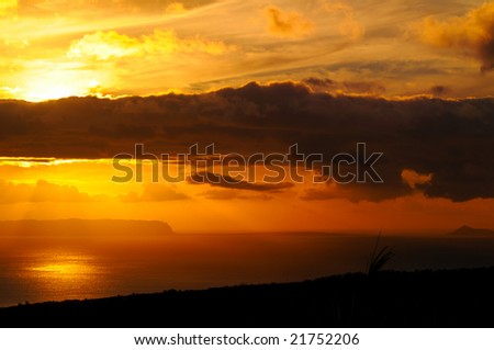 Sunset with dark clouds over the island of Niihau, Hawaii, taken from high ground on Kauai