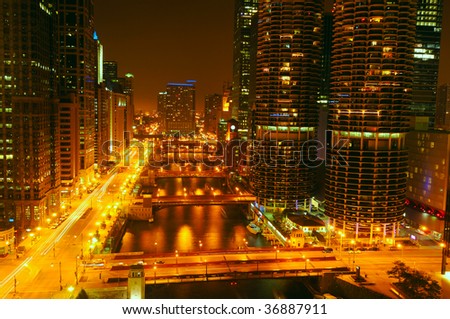 City lights glow over the Chicago River at night in Chicago Illinois