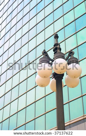 Contrast: old-fashioned lamp post in front of modern glass building
